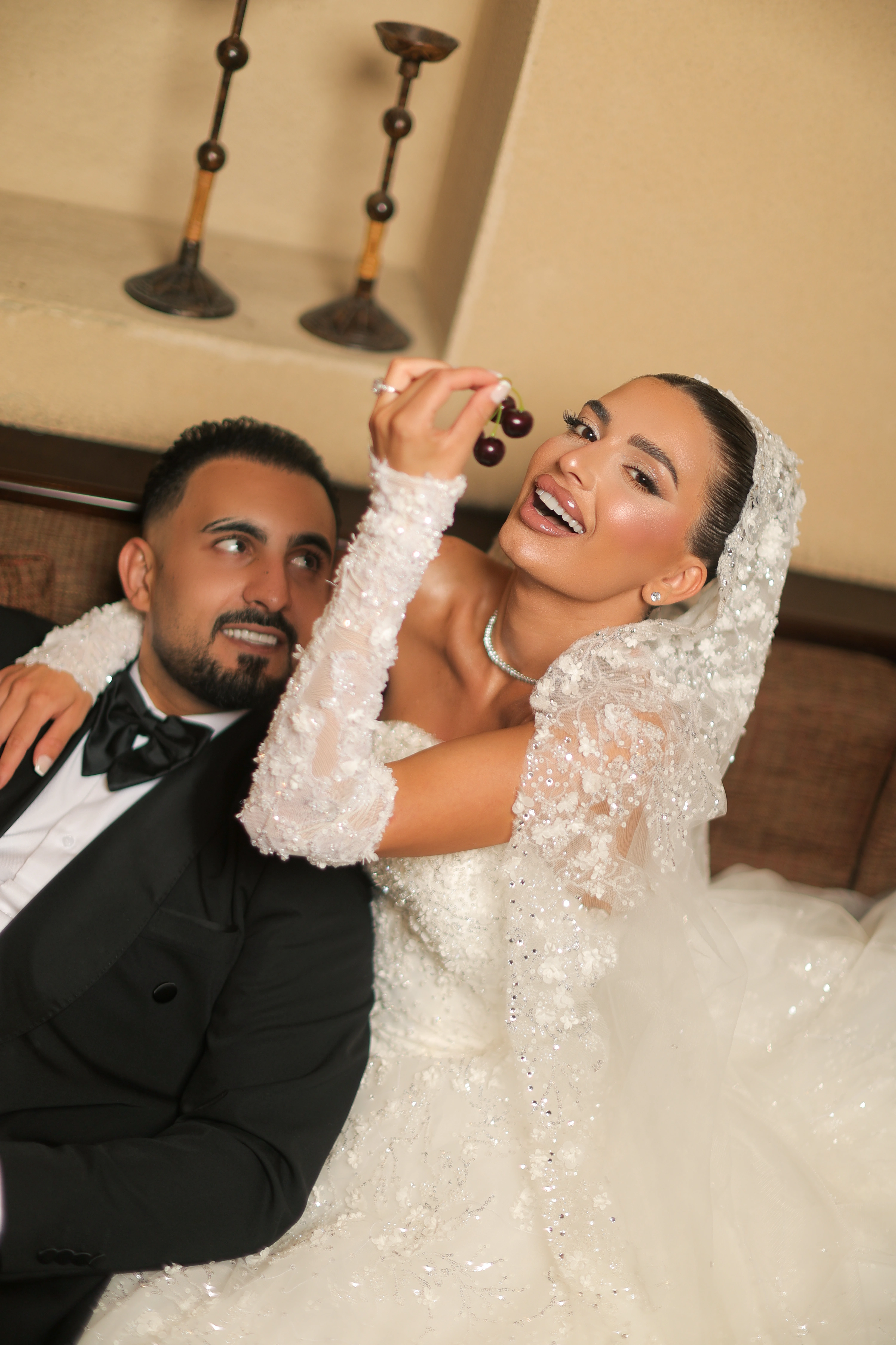 Bride holding cherries beside the groom