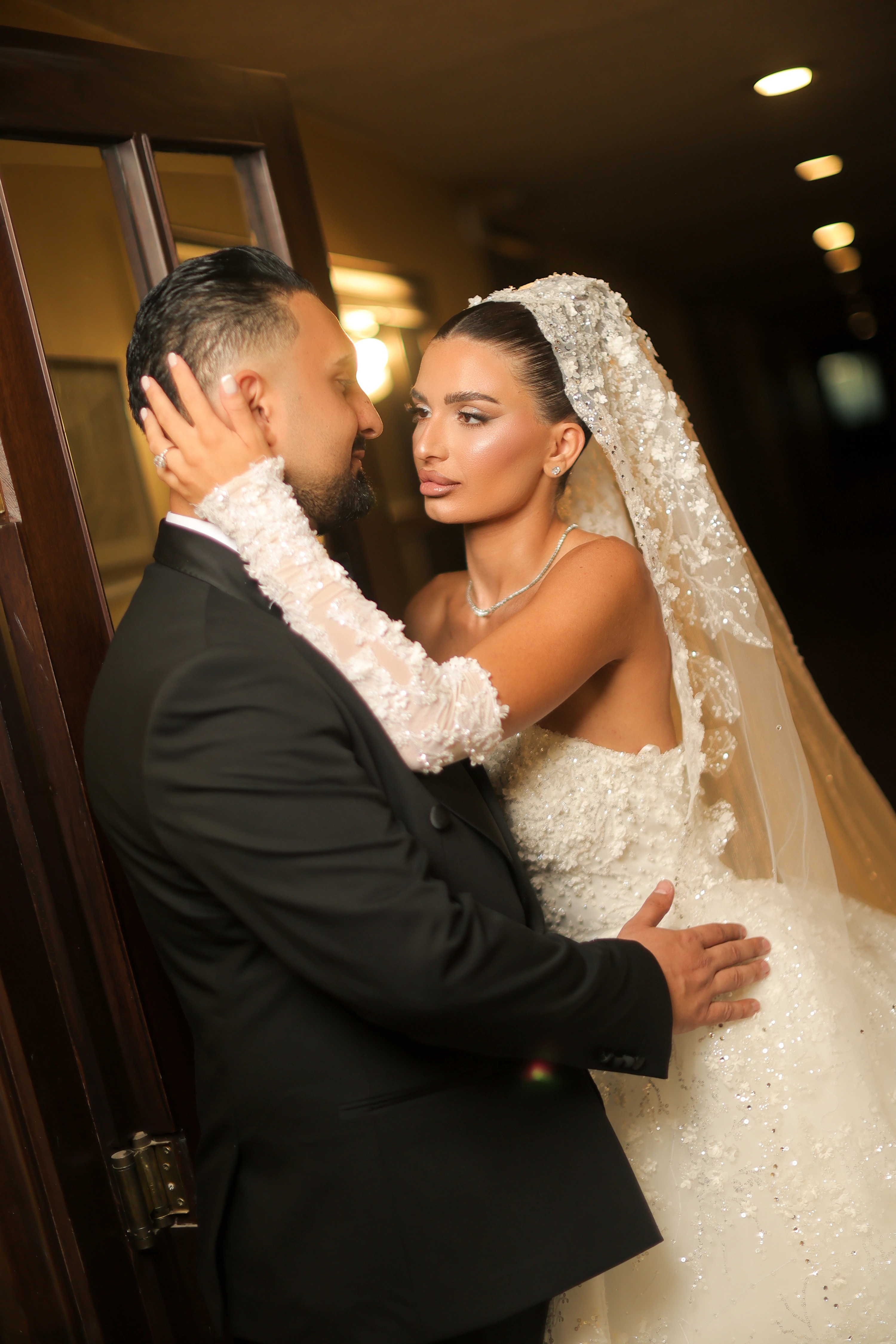 Bride and groom embracing in a warmly lit doorway